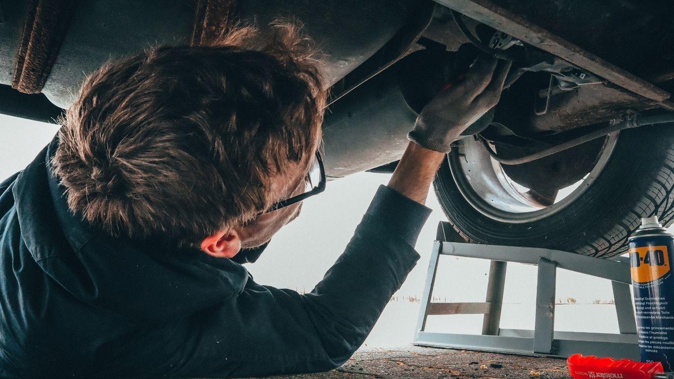 ### Key Elements - **Main Subject**: A person working underneath a vehicle. - **Objects**: Tools,